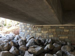 A pile of rocks under a bridge.
