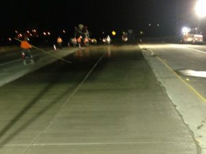 A group of people working on a road at night.