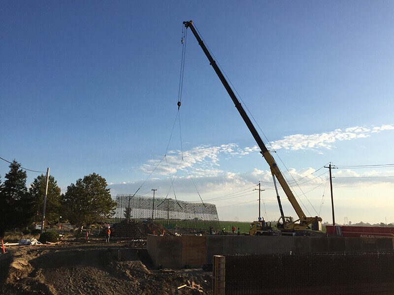 A crane is being used to lift a large piece of concrete.