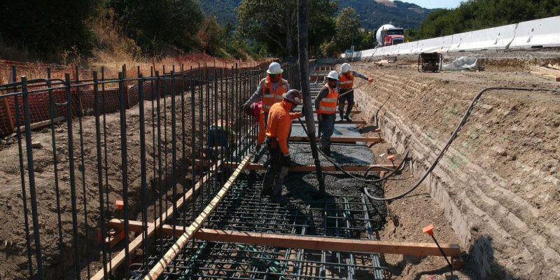 A group of construction workers are working on a road.