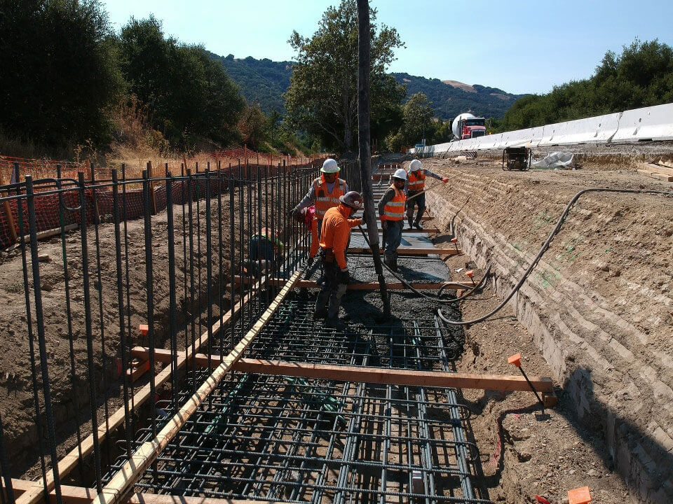 A group of construction workers are working on a road.