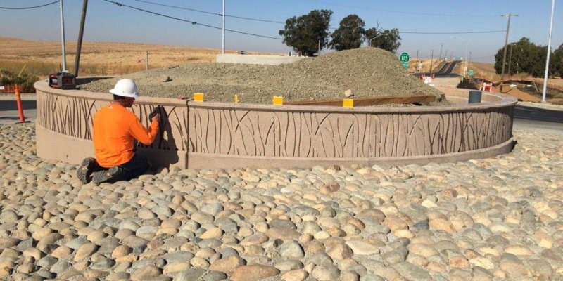 A construction worker is working on a roundabout.