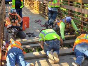 A group of construction workers working on a wooden bridge.