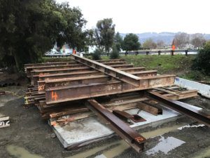 A large pile of steel beams on the ground.