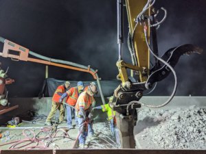 A group of people working on a construction site at night.