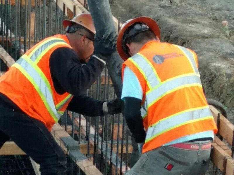 Two construction workers working on a construction site.