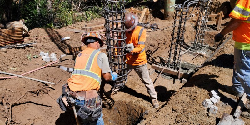 Two men working on a hole in the ground.