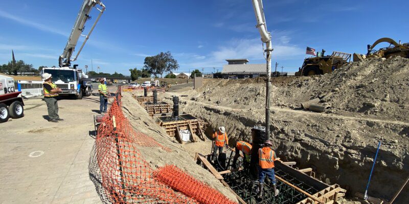 A construction site with workers working on the ground.