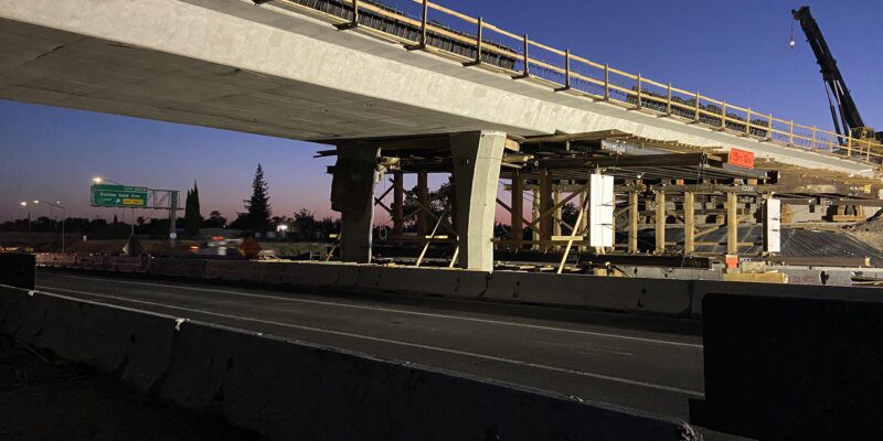 A bridge that is under construction over the road.