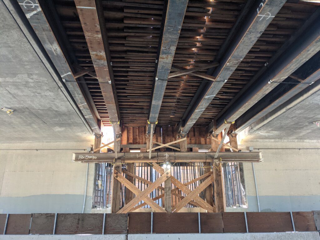 A ceiling with wooden beams and metal bars.