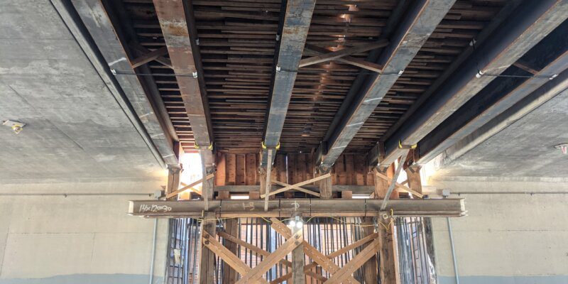 A ceiling with wooden beams and metal bars.